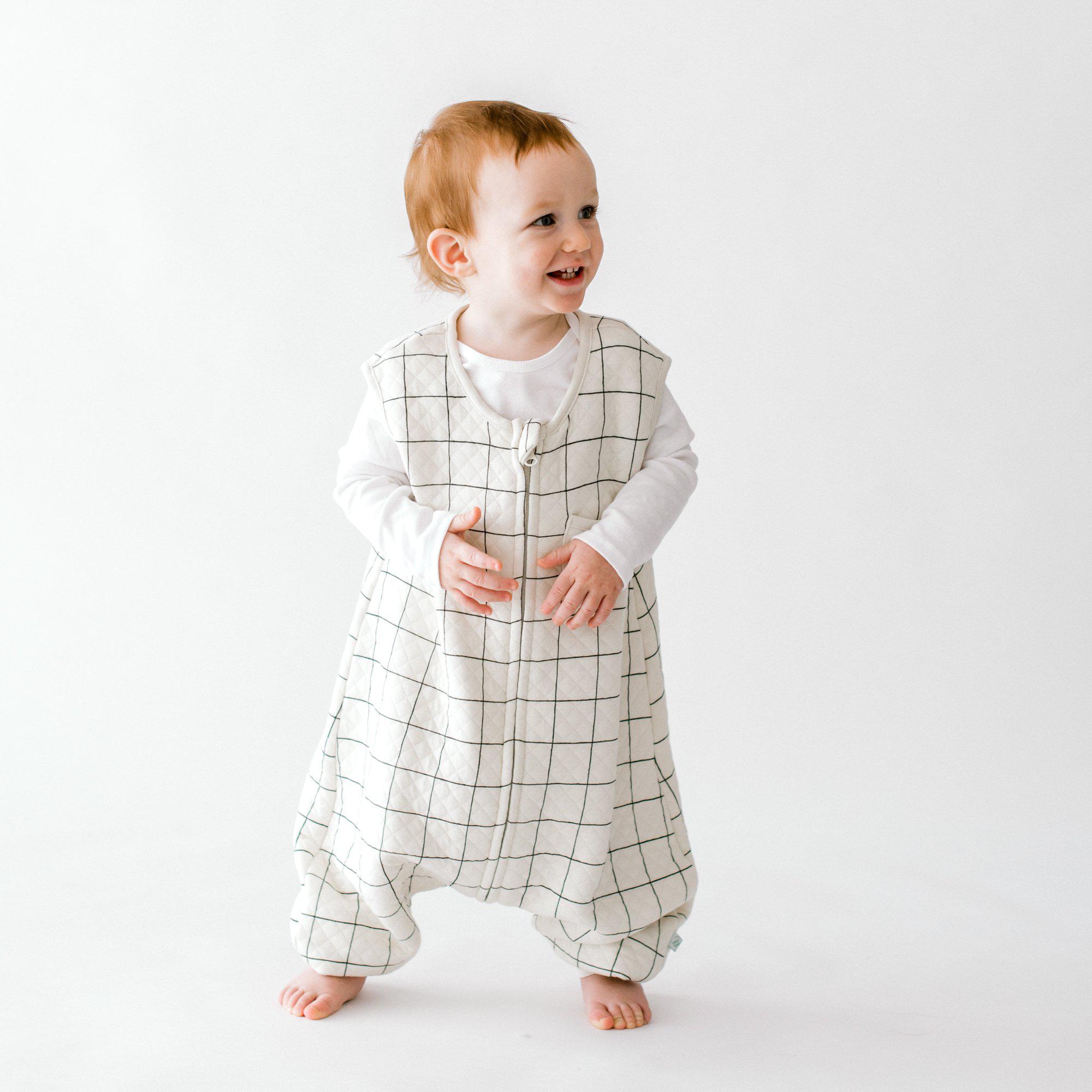 Toddler wearing Tealbee Dreamsuit Checkered. print front view, blocks are blacky and each block measures a couple of inches. Also highlighing quilted fabric.